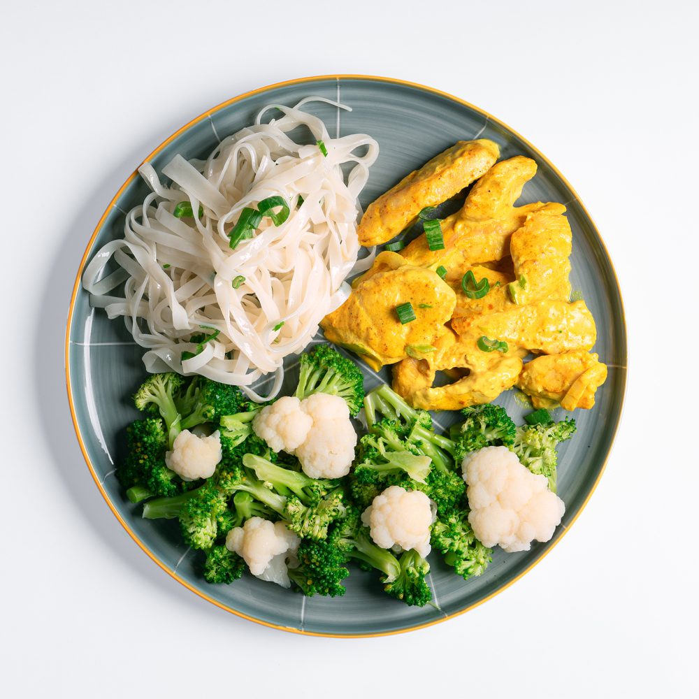 Tiritas de pollo al curry y ensalada de brocoli y coliflor